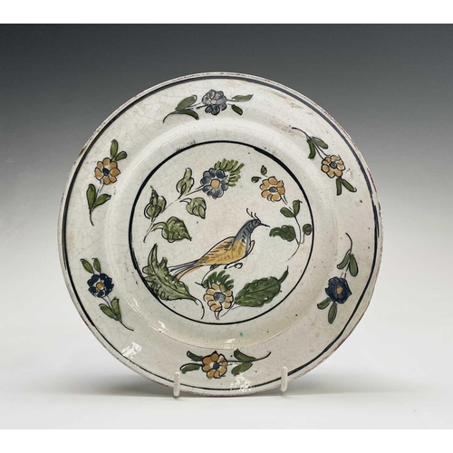 896 - A Greek earthenware plate, 19th century, painted in ochre, green and blue with a bird and flowers, t... 