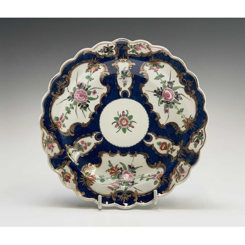 909 - A Worcester porcelain plate, circa 1770, the blue scale ground decorated with gilt edged floral pane... 