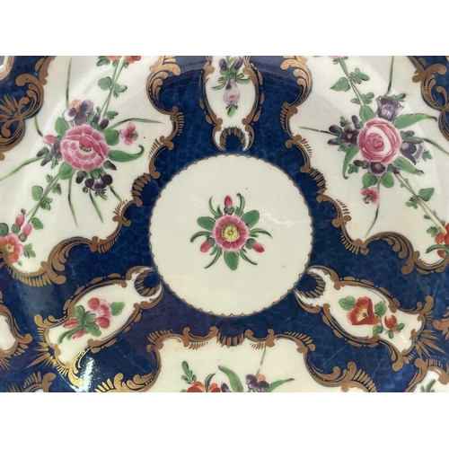 909 - A Worcester porcelain plate, circa 1770, the blue scale ground decorated with gilt edged floral pane... 