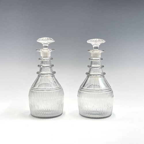 911 - A pair of Regency triple ring neck glass decanters and stoppers, with faceted and fluted decoration,... 