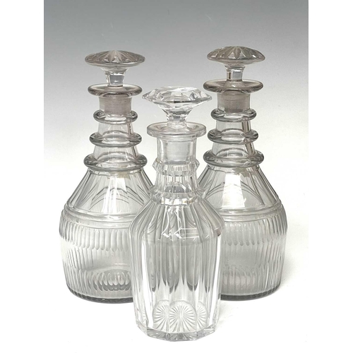 911 - A pair of Regency triple ring neck glass decanters and stoppers, with faceted and fluted decoration,... 