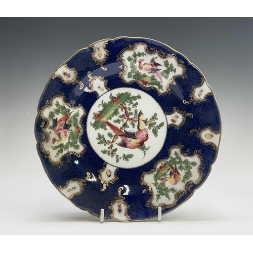 915 - A Continental porcelain mug, in the Worcester style, the blue scale ground with panels of an exotic ... 