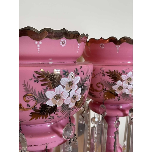 924 - A pair of Victorian pink opaque glass lustre vases, with floral painted and gilt decoration and cut ... 