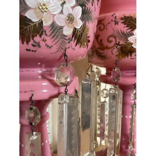 924 - A pair of Victorian pink opaque glass lustre vases, with floral painted and gilt decoration and cut ... 