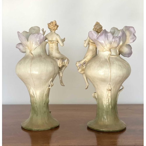 927 - A pair of Austrian Art Nouveau porcelain figural vases, moulded with seated females beside lilies an... 