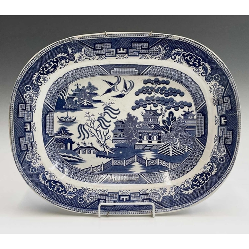 940 - A 19th century blue and white meat platter, printed with figures beside ruins, width 47cm, together ... 