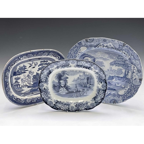 940 - A 19th century blue and white meat platter, printed with figures beside ruins, width 47cm, together ... 