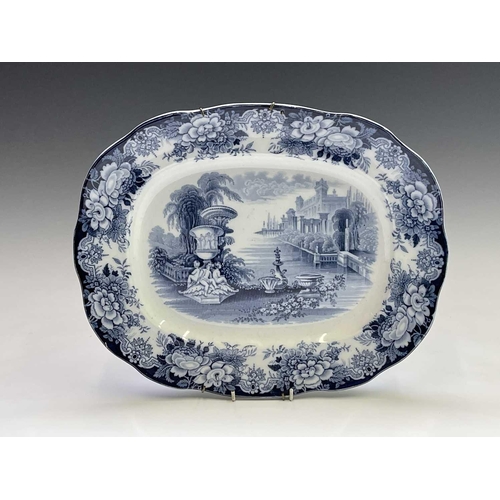 940 - A 19th century blue and white meat platter, printed with figures beside ruins, width 47cm, together ... 