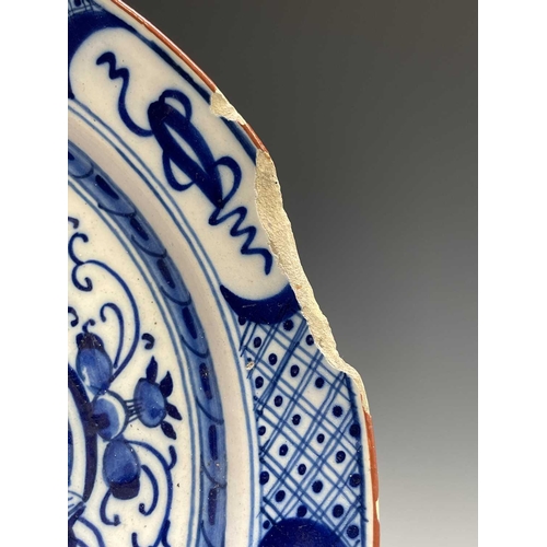 951 - A pair of 18th century Dutch blue and white delft plates, the centres decorated with a floral arrang... 