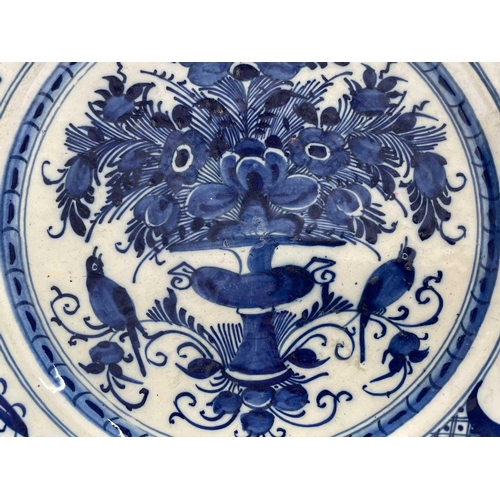 951 - A pair of 18th century Dutch blue and white delft plates, the centres decorated with a floral arrang... 