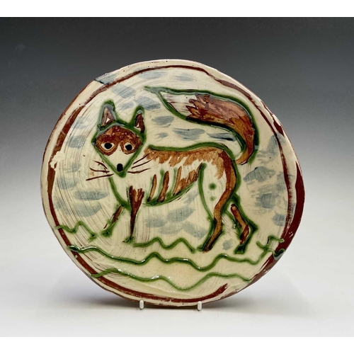 958 - A Ben Fosker (b.1960) slip decorated earthenware plate painted with a fox. Diameter 24cm.