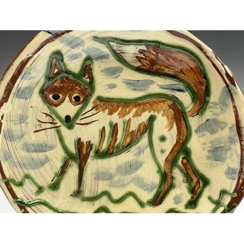 958 - A Ben Fosker (b.1960) slip decorated earthenware plate painted with a fox. Diameter 24cm.