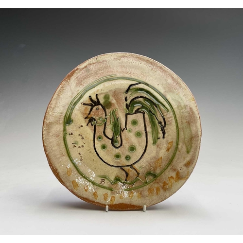 959 - A Ben Fosker (b.1960) slip decorated earthenware plate painted with a cockerel. Diameter 23.5cm.