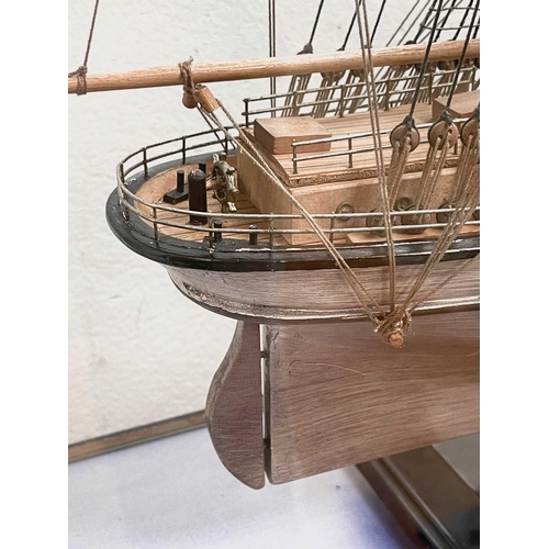 99 - A wooden model of the Cutty Sark, with stained hull and gilt detail, on a stand and contained in a g... 