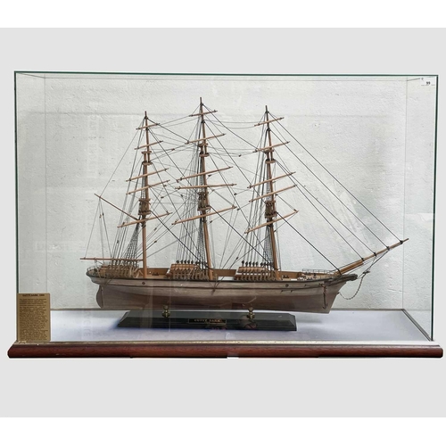 99 - A wooden model of the Cutty Sark, with stained hull and gilt detail, on a stand and contained in a g... 