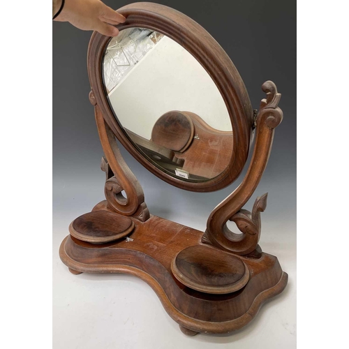 3045 - A Victorian mahogany swing toilet mirror, with oval plate, the base fitted two jewellery compartment... 