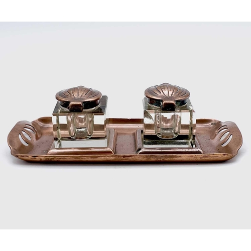 101 - An Aesthetic Movement copper inkstand, circa 1900, with pierced grips and fitted two copper topped g... 