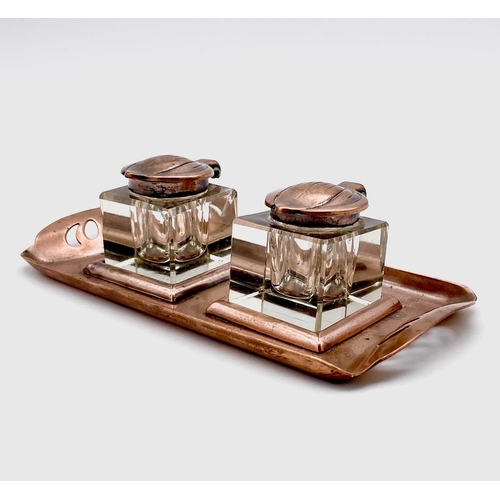 101 - An Aesthetic Movement copper inkstand, circa 1900, with pierced grips and fitted two copper topped g... 