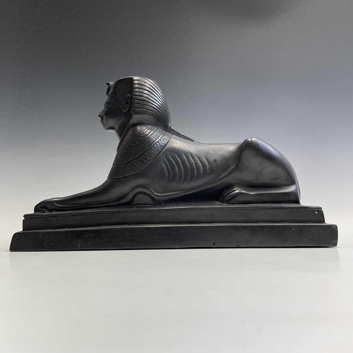 112 - A black onyx carved recumbent lion and a carved black stone sphinx, largest height 18cm width 29cm d... 