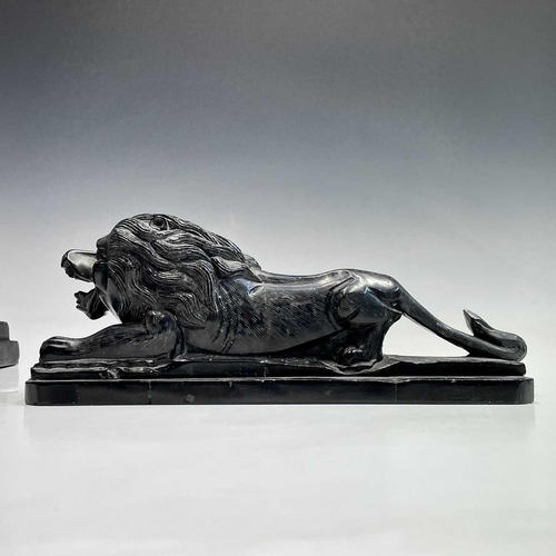 112 - A black onyx carved recumbent lion and a carved black stone sphinx, largest height 18cm width 29cm d... 