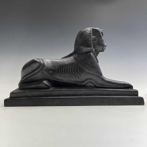 112 - A black onyx carved recumbent lion and a carved black stone sphinx, largest height 18cm width 29cm d... 