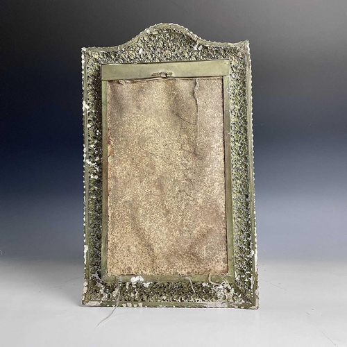 118 - An early 20th century wall-mounted brass mirror with pierced frame, the obverse later painted. Maxim... 