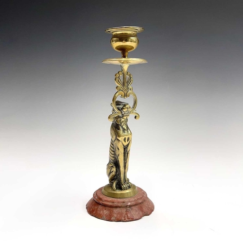 121 - A 19th century cast brass candlestick, the nozzle supported by a panther, height 20.5cm, together wi... 