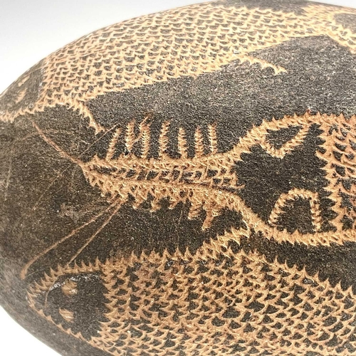 154 - An Australian Aboriginal carved boab nut the incised decoration depicting aquatic life including a c... 