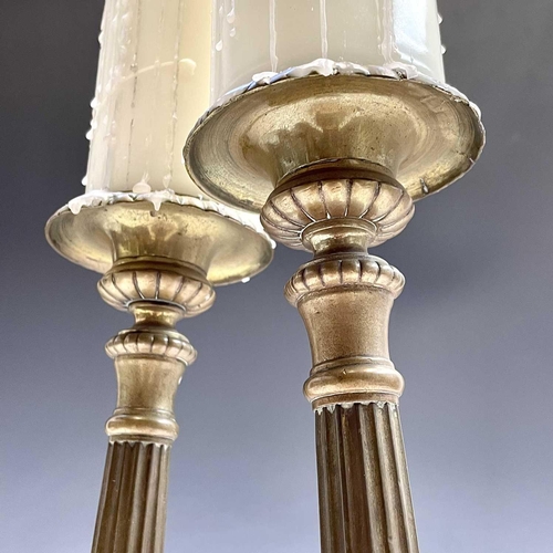 168 - A pair of brass candlesticks the tripod bases with religious imagery, height 38.5cm.