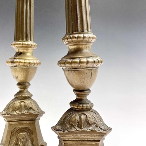 168 - A pair of brass candlesticks the tripod bases with religious imagery, height 38.5cm.