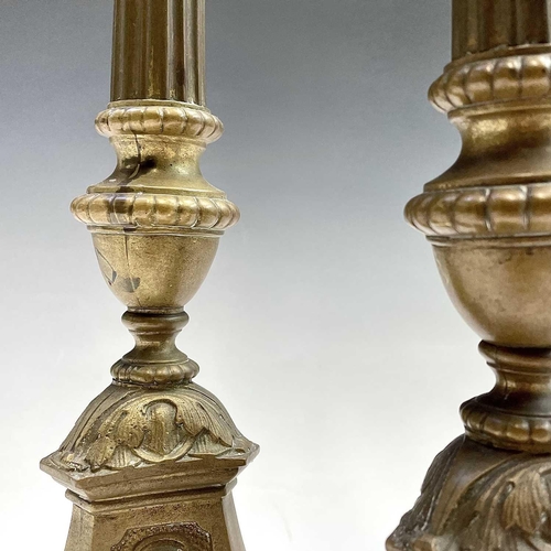 168 - A pair of brass candlesticks the tripod bases with religious imagery, height 38.5cm.