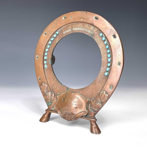 180 - An early 20th century copper frame in the form of an inverted horseshoe decorated with turquoise bea... 