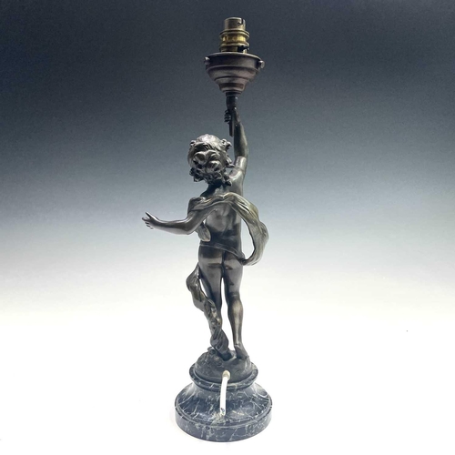 23 - After Auguste Moreau, a bronzed lamp, modelled as a cherubic youth supporting the torch in his raise... 