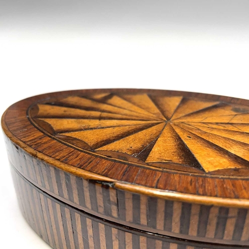 28 - A George III mahogany, crossbanded and satinwood inlaid oval trinket box, with large paterae to the ... 