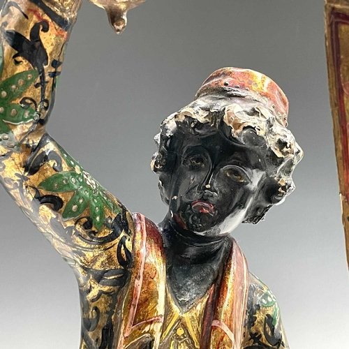 3 - A Venetian blackamoor gondolier figure, circa 1900, with painted and gilt decoration, modelled stand... 