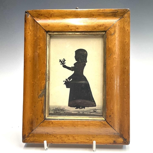 32 - An early 19th century silhouette, of a young girl, in a coastal setting holding a toy dog, heightene... 