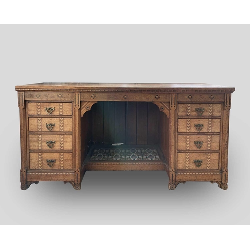 3206 - A Victorian Gothic revival oak ebony and boxwood inlaid twin pedestal desk, with an arrangement of e... 