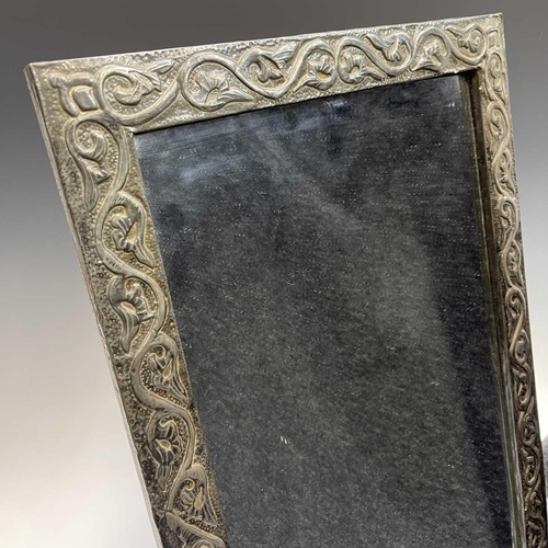 321 - A 20th century pewter framed mirror decorated in foliate scrolls, 58cm x 37.5cm.