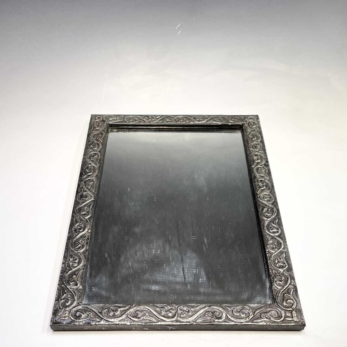 321 - A 20th century pewter framed mirror decorated in foliate scrolls, 58cm x 37.5cm.