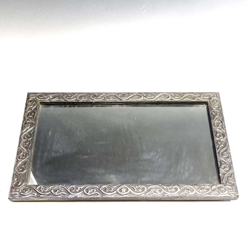 321 - A 20th century pewter framed mirror decorated in foliate scrolls, 58cm x 37.5cm.