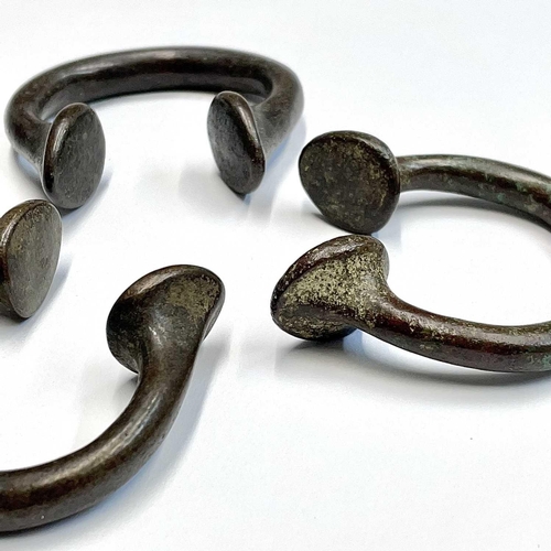 48 - Three bronze Manilla slave bangles.