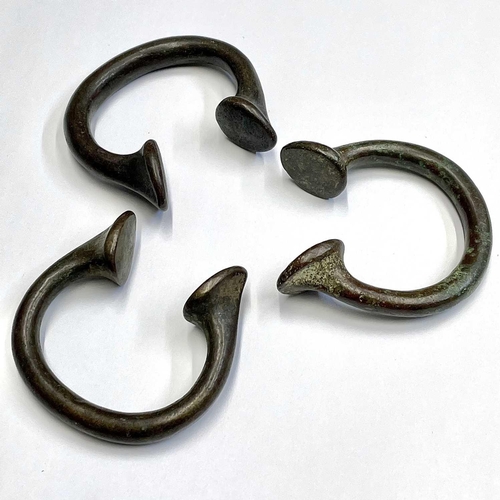 48 - Three bronze Manilla slave bangles.