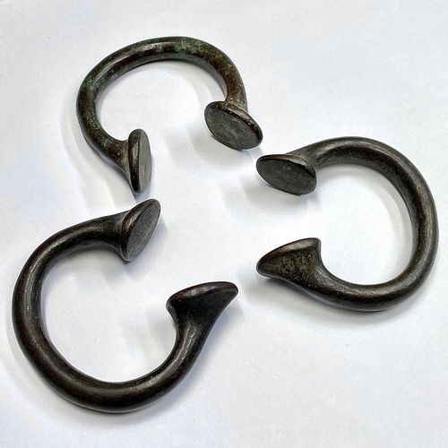 48 - Three bronze Manilla slave bangles.