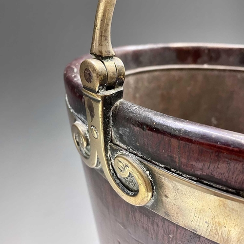 5 - A George III mahogany and brass bound plate bucket, the brass swing handle with decorative scroll te... 