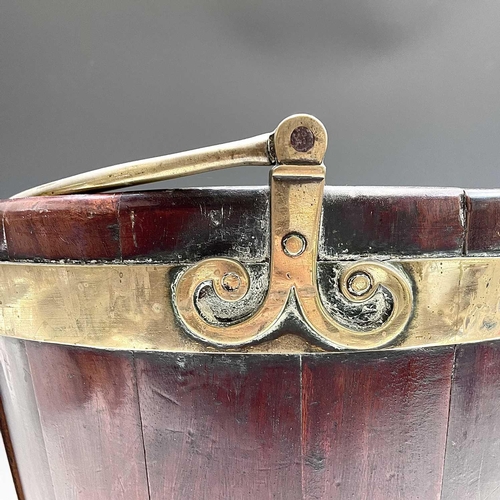 5 - A George III mahogany and brass bound plate bucket, the brass swing handle with decorative scroll te... 