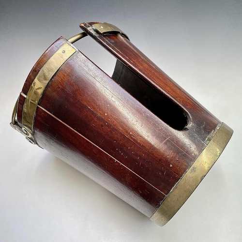 5 - A George III mahogany and brass bound plate bucket, the brass swing handle with decorative scroll te... 