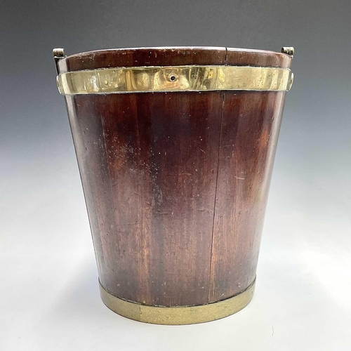 5 - A George III mahogany and brass bound plate bucket, the brass swing handle with decorative scroll te... 