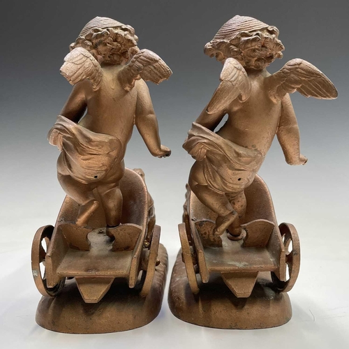 70 - A pair of late 19th/early 20th spelter figure groups, each modelled as a cherub standing in a chario... 