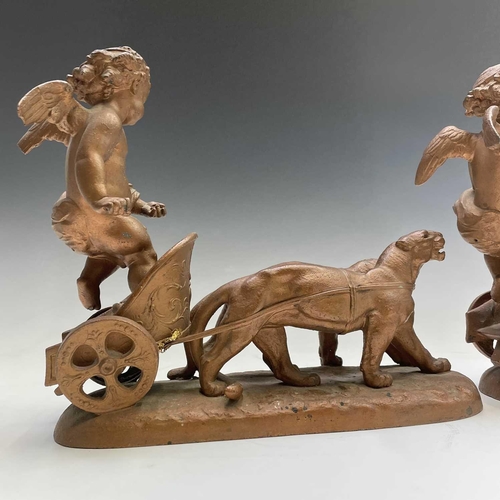 70 - A pair of late 19th/early 20th spelter figure groups, each modelled as a cherub standing in a chario... 