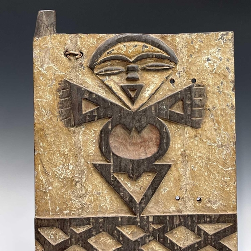 77 - An African wood carved panel of a stylised figure above a trellis pattern. and an African wood carve... 